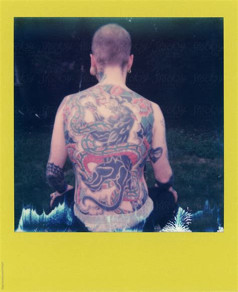 Polaroid Scan Of A Heavily Tattooed Man Sitting Outside By Stocksy