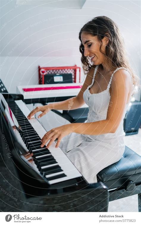 Lächelnde Frau spielt Klavier im Wohnzimmer ein lizenzfreies Stock Foto von Photocase