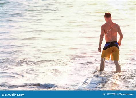 Man Standing In The Water At The Beach Stock Image Image Of Blue