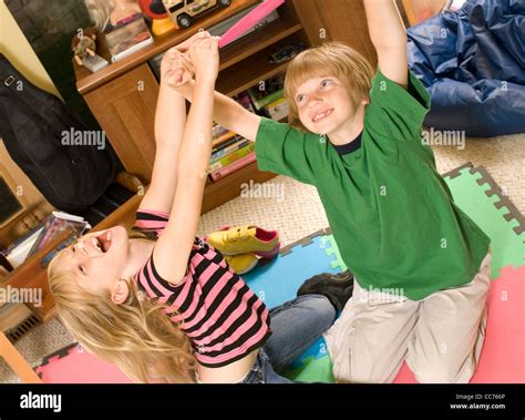 Twins Wrestling And Tickling In Their Playroom Stock Photo Alamy