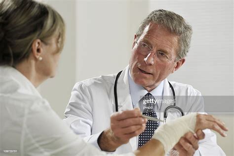 Senior Male Doctor Treating Female Patient High Res Stock Photo Getty