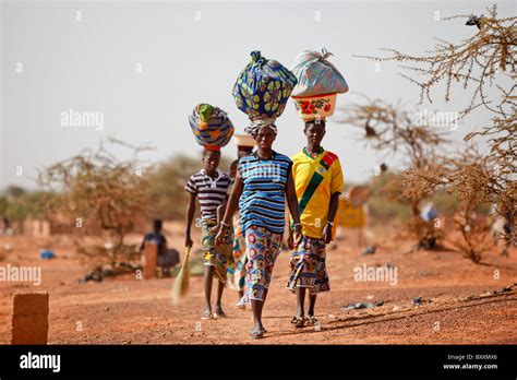Women Arrive In The Town Of Djibo Burkina Faso On Foot Carrying Their