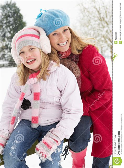 Mother And Daughter Standing Outside In Snow Stock Image
