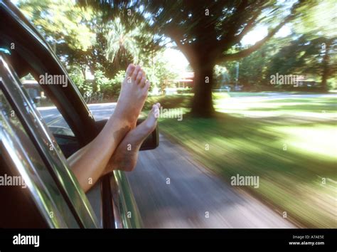 Teenage Girl Sticking Her Bare Feet Out The Window Of A Moving Car