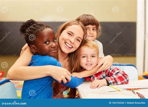 Happy Children Hug Their Educator Stock Photo Image Of Childhood