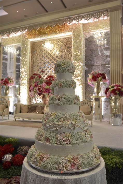 A Large Wedding Cake Sitting On Top Of A Table In Front Of A Stage With