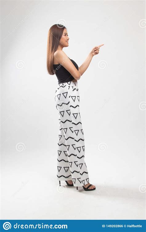 Full Body Side View Of Beautiful Young Asian Woman Pointing Stock Photo