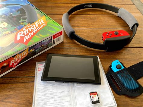 The ring fit adventure game cartridge and the two accessories which are the exercise ring and a joy con pouch strap. New Ring Fit Adventure: Nintendo Switch Bundle Workout Package