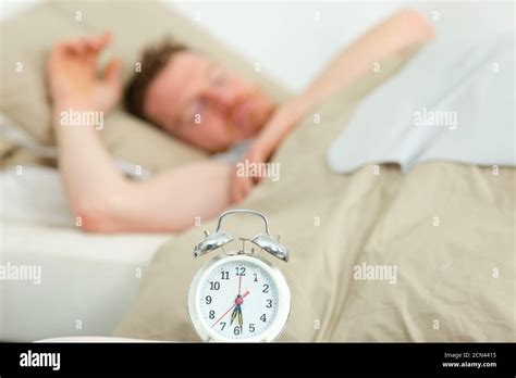 Alarm Clock Waking Sleeping Man In Bed Stock Photo Alamy