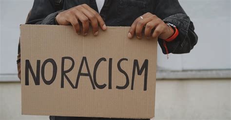Person Holding A Cardboard Wiht No Racism Text · Free Stock Video