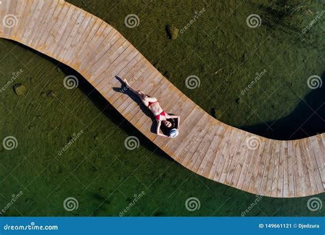 Drone Aerial View Of Young Beauty Woman Sunbathing On The Sea Pier