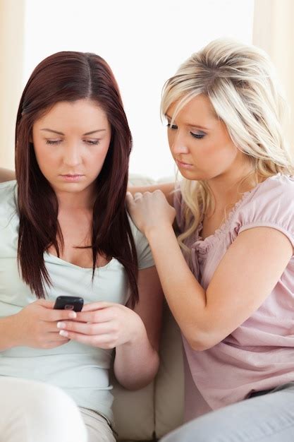 Premium Photo Shocked Women Sitting On A Sofa With A Phone