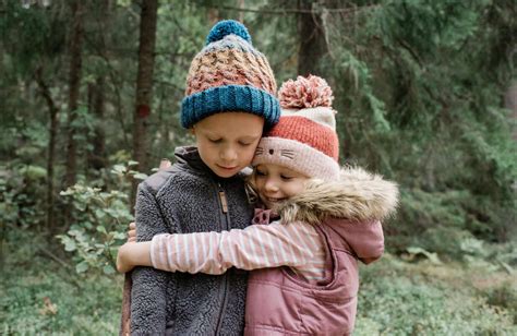 bruder und schwester umarmen sich beim spielen im wald lizenzfreies stockfoto