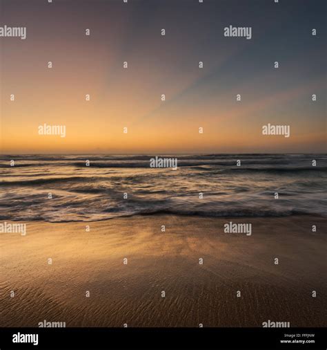 Golden Hour Seascape With Soft Light God Rays And Golden Sand Stock