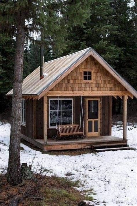 A Small Cabin In The Woods With Snow On The Ground