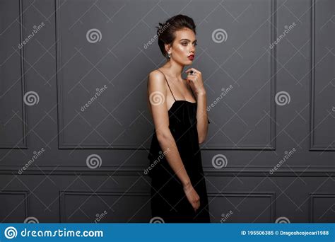 Portrait Of A Sensual Brunette Woman In Black Dress With Bare Shoulders