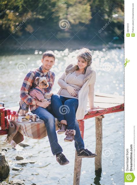 Young Future Parents And Their Dog In A Funny Costume Sitting On A