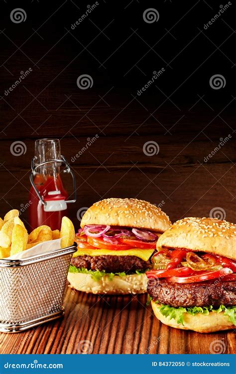 Two Delicious Burgers On Table With Fries Stock Photo Image Of Burger