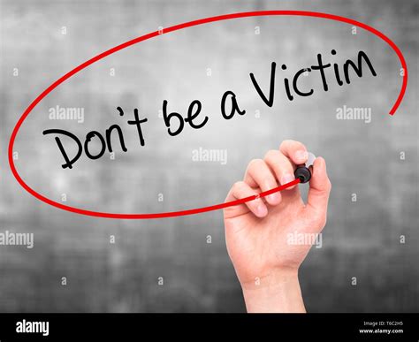 Man Hand writing Don't be a Victim with black marker on visual screen