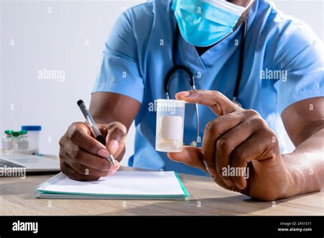 African American Male Health Worker Wearing Face Mask Holding