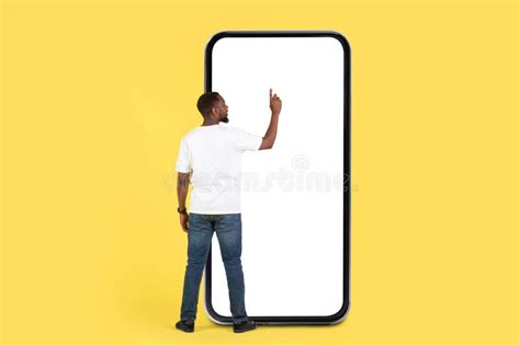 Black Man Using Huge Phone Screen Yellow Background Back View Stock