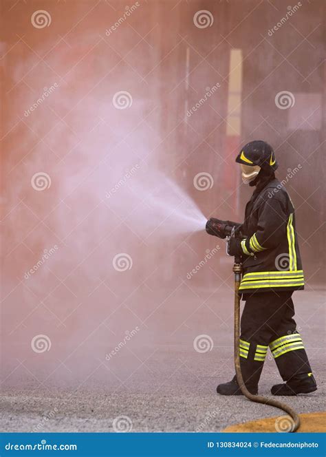 Firefighter Uses A Fire Extinguisher To Extinguish A Fire Stock Photo
