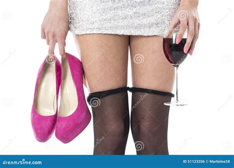 Woman With Stocking Rolled Down Holding High Heels And Glass Of Wine