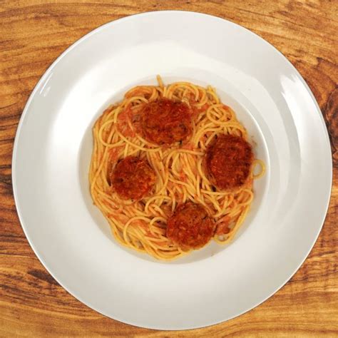 Chicken meatballs are simmered in a homemade tomato sauce and served with spaghetti noodles. Chicken Meatballs Pasta - Frixos Personal Chefing