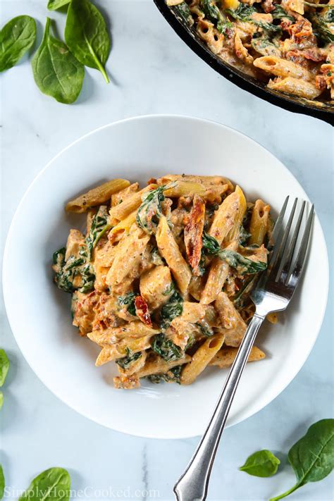 Garlic is pan fried in sun dried tomato oil, followed closely by sun dried tomatoes releasing all of their flavours in a mouthwatering cream sauce. Plate of Creamy Tuscan Chicken Pasta with a fork, and ...