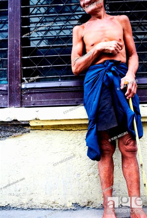 A Shirtless Old Man Standing On The Side Of The Road With A Cane Stock Photo Picture And Low