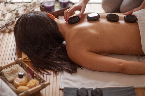 Woman Receiving Hot Stone Massage By Stocksy Contributor Mosuno