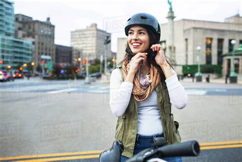 Woman wearing helmet while standing with bicycle in city - Stock Photo ...