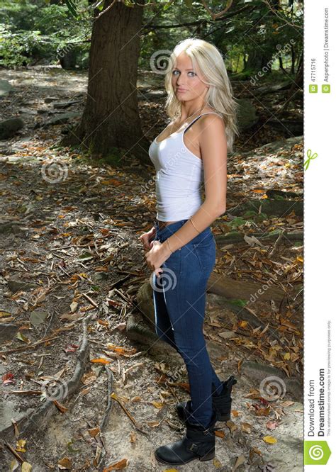 Beautiful Blonde Woman In White Tank And Jeans In Woods