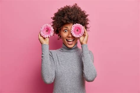 Die Glückliche Afroamerikanische Frau Bedeckt Die Augen Mit Rosigen Gerbera Blumen Hat Spaß Und