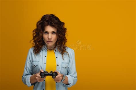 Redhead Woman Biting Lips While Playing Video Game On Orange Stock Image Image Of Play Girl