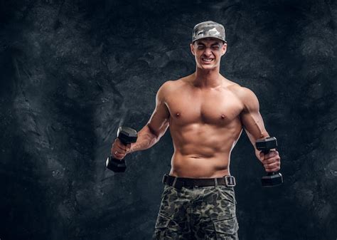 Free Photo Attractive Shirtless Man In Cap Is Doing Exercises With Dumbbells Over Dark Background