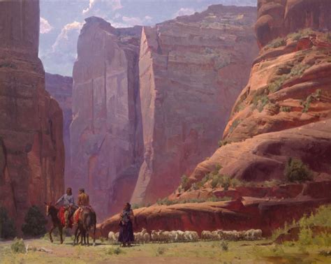Two People Riding Horses Through A Canyon With Mountains In The Background