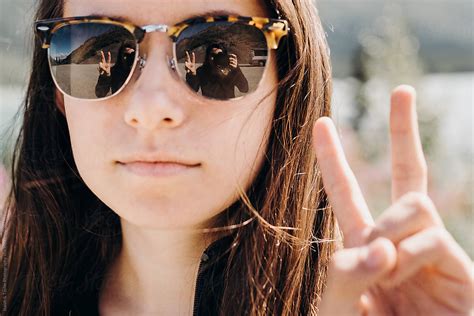 Woman With Sunglasses Giving Peace Sign By Stocksy Contributor Itla