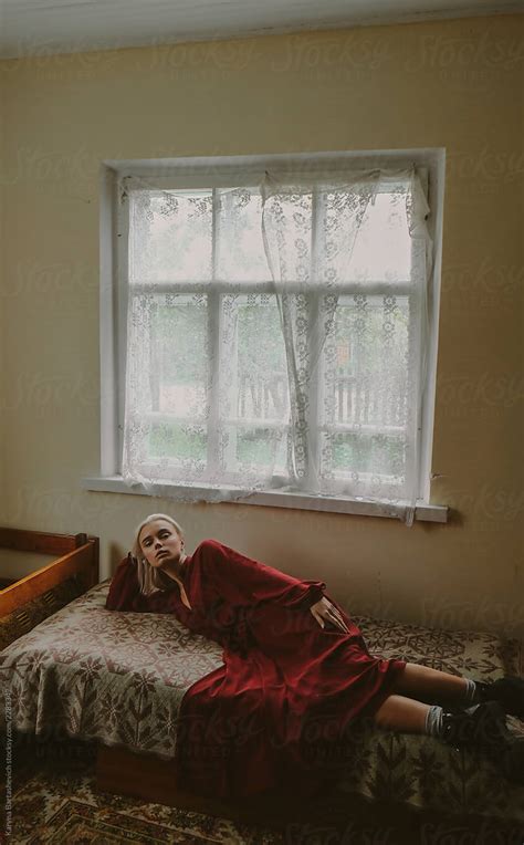 Girl In A Cherry Dress Is Lying On The Bed In The Old Room Of The Old
