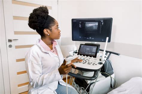 Young African American Female Doctor In White Coat Using Ultra