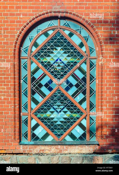 Stained Glass Arched Window In Red Brick Wall Facade Front View Stock