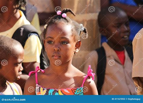 jamaican school girls wide brown eyes shy little sister leaning on shoulder of older sister