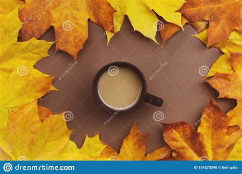 Cup Of Coffee In And Fallen Autumn Leaves On A Brown Background Stock