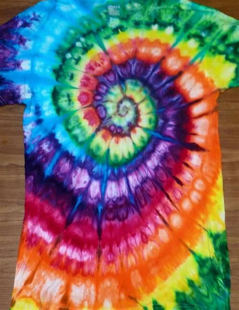 A Colorful Tie Dyed T Shirt Is Laying On A Wooden Floor And It