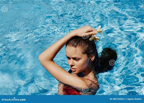 Young Woman In Swimming Pool In Red Swimsuit With Beautiful Smile And