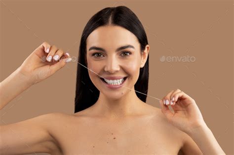 Portrait Of Attractive Cheerful Naked Woman Using Dental Thread Stock