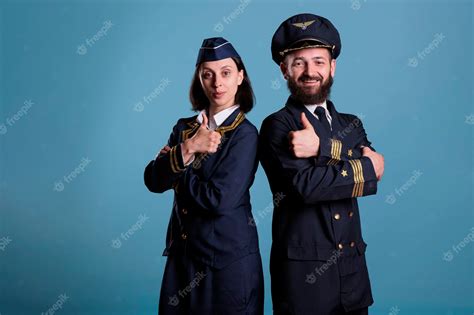 Premium Photo Smiling Airplane Pilot And Flight Attendant Showing Thumbs Up Gesture Portrait
