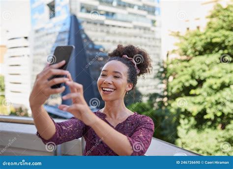 A Young Woman Takes A Selfie On The Balcony Of A City Building Stock