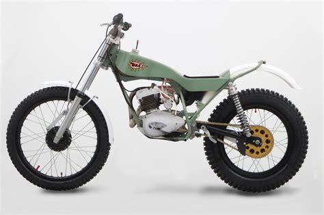 A Green And White Dirt Bike Parked In Front Of A White Wall