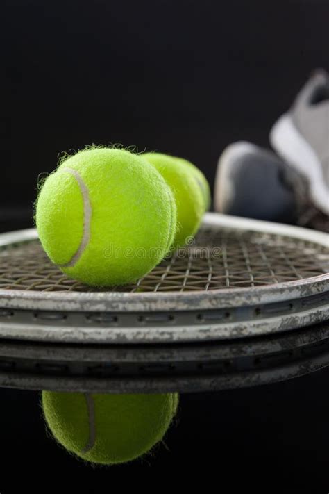 Close Up Of Fluorescent Yellow Tennis Balls On Racket By Sports Shoes